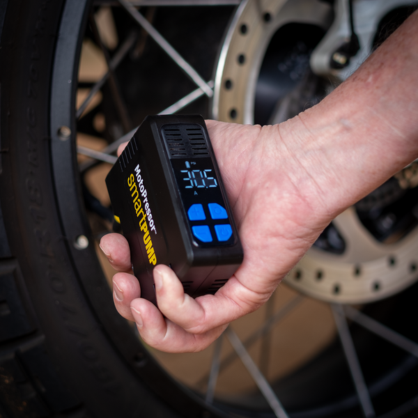 MotoPressor SmartPUMP cordless motorcycle tyre inflator being used to check tyre pressure

